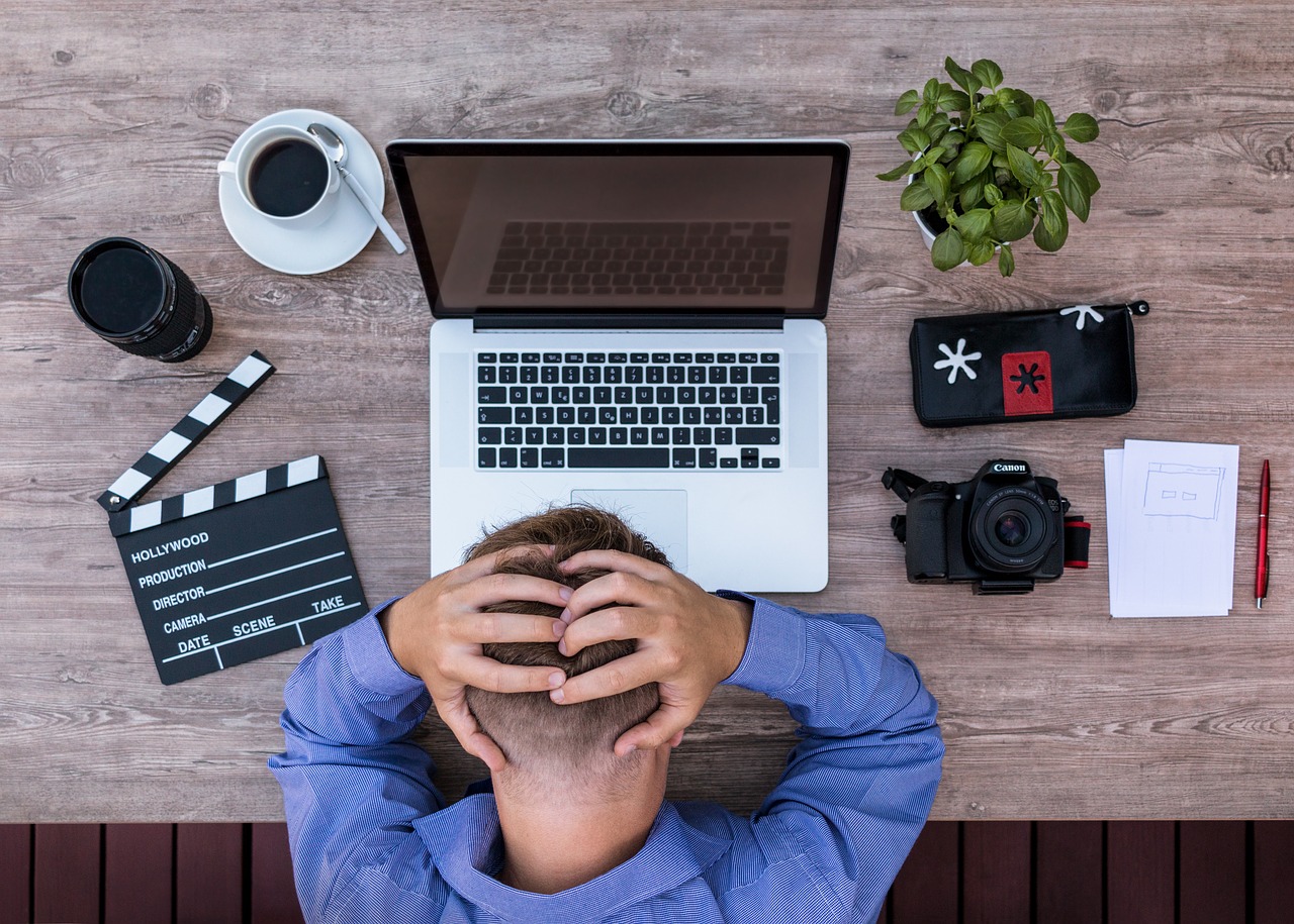 man at desk with his head in his hands