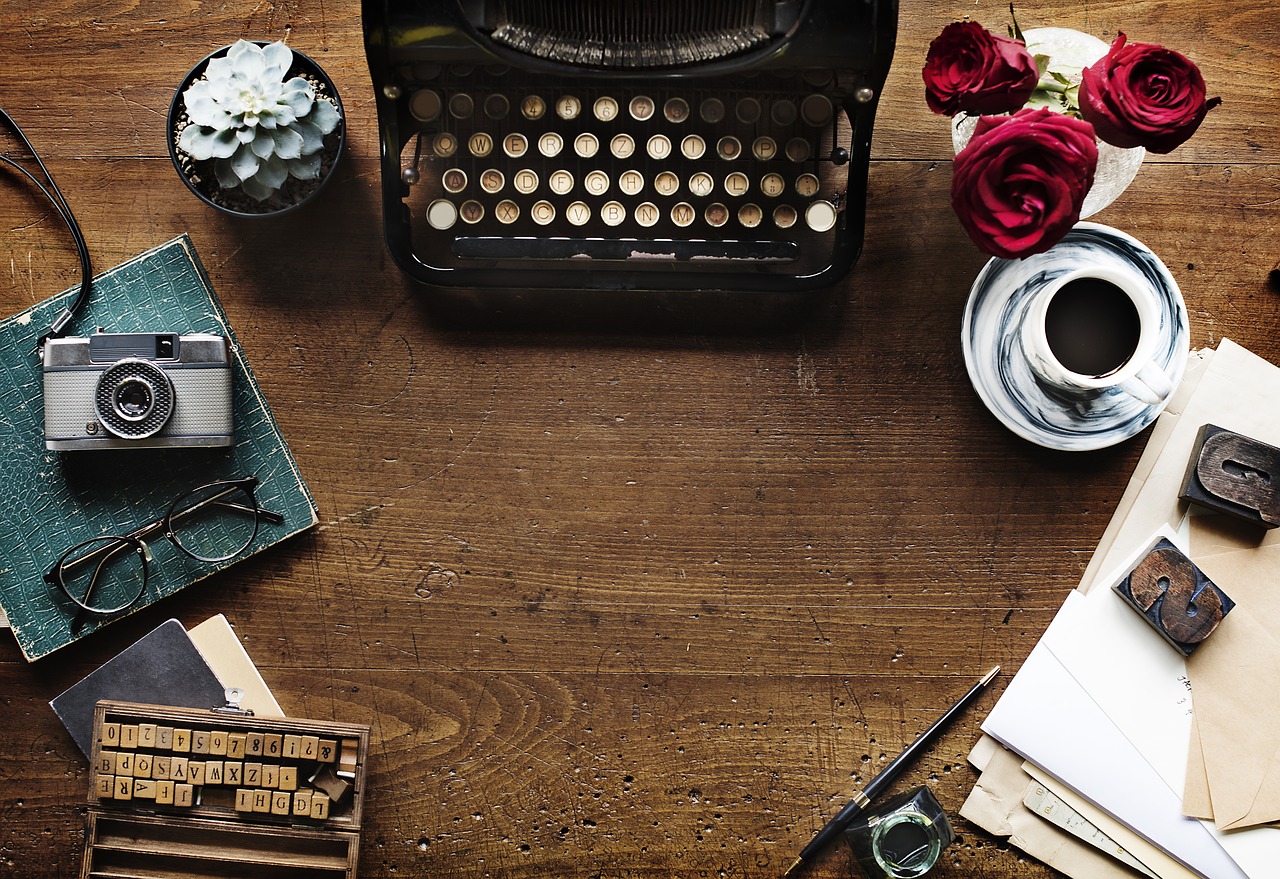 desk top with various media including typewriter and camera