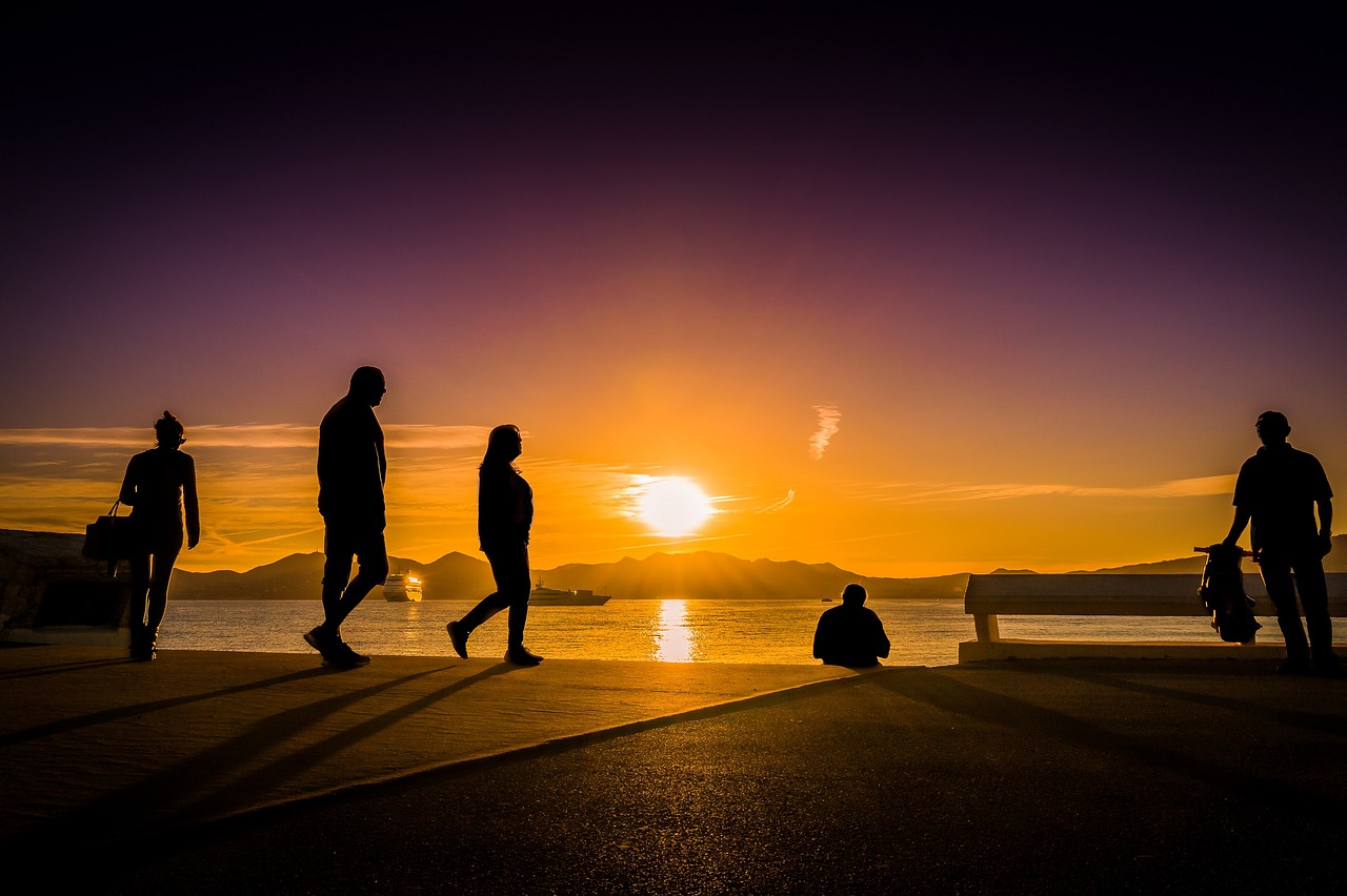 Walkers in silhouette against sunset