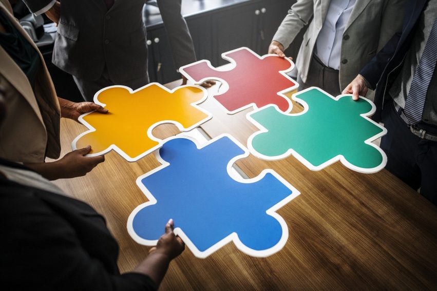 Business people with jigsaw pieces